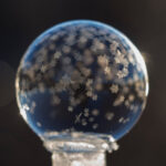 Eine Glaskugel mit sternförmigen Kristallen außen 