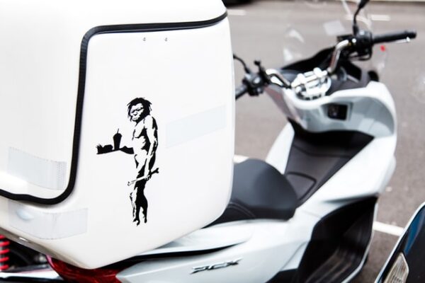 Ein weißer Motorroller mit einem kleinen Logo auf dem Koffer