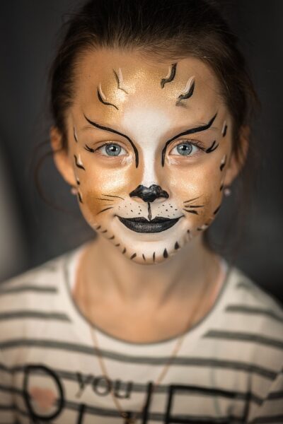 Ein Mädchen, dessen Gesicht wie ein Tiger geschminkt wurde