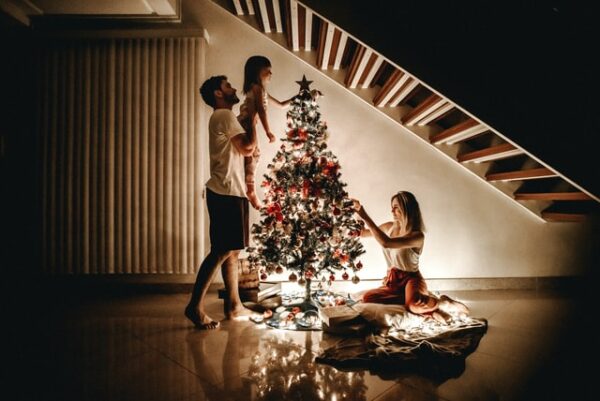 Eine Familie schmückt einen Weihnachtsbaum