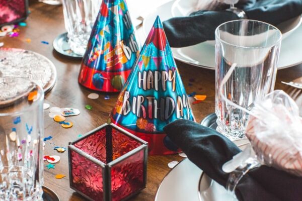 Ein Tisch ist für einen Geburtstag mit Partyhüten, Teelichtern und Co. gedeckt